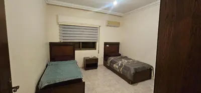 a bedroom with two beds and a window at شقة مفروشة في طبربور 3 غرف نوم in Amman