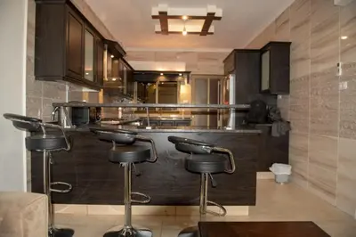 a kitchen with a bar with stools in it at شقة مفروشة في طبربور 3 غرف نوم in Amman