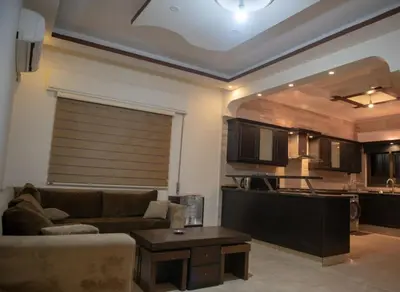 a living room with a couch and a kitchen at شقة مفروشة في طبربور 3 غرف نوم in Amman