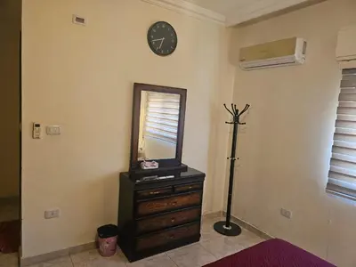 a room with a mirror and a dresser and a clock at شقة مفروشة في طبربور 3 غرف نوم in Amman
