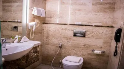 a bathroom with a sink and a toilet and a phone at Olive Tree Amman in Amman
