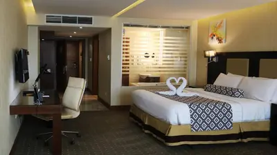 a hotel room with a bed with a swan on it at Olive Tree Amman in Amman