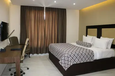 a hotel room with a bed and a desk at Olive Tree Amman in Amman