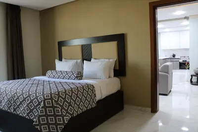 a bedroom with a large bed with pillows at Olive Tree Amman in Amman
