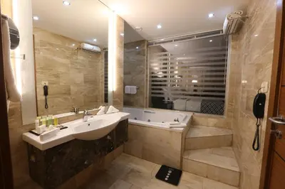 a bathroom with a sink and a bath tub at Olive Tree Amman in Amman