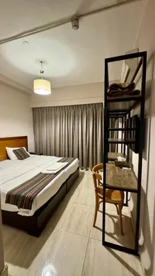 a bedroom with a bed and a chair and a ladder at Antika Amman Hotel in Amman