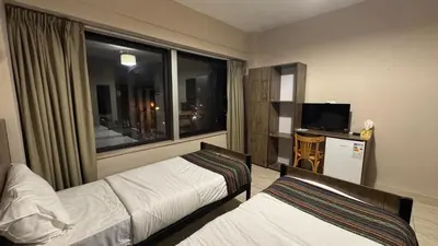 a hotel room with two beds and a window at Antika Amman Hotel in Amman