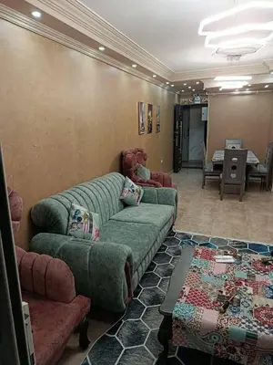 a living room with a green couch and chairs at رميمين هاوس