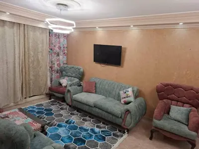 a living room with a couch and chairs and a tv at رميمين هاوس