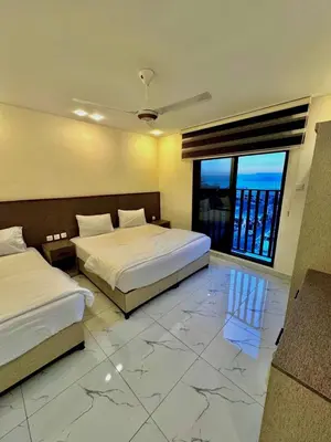 a bedroom with two beds and a large window at Old Town Hotel in Aqaba