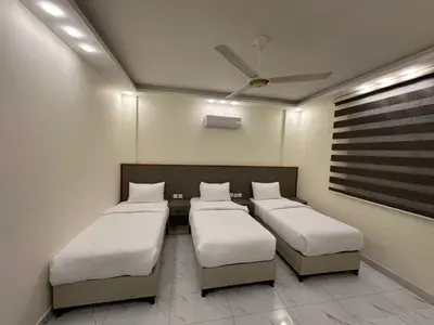 a room with three beds and a ceiling fan at Old Town Hotel in Aqaba