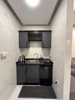 a kitchen with black cabinets and a sink at Old Town Hotel in Aqaba
