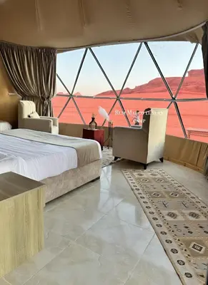 a bedroom with a bed and a view of the desert at Rum marco luxury camp in Wadi Rum