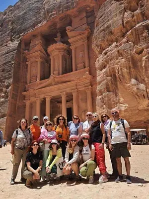 a group of people posing in front of thearaoh at Tourist guide in Al Jafr