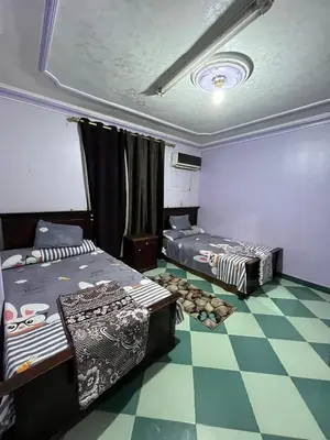 two beds in a room with a checkered floor at سونا موتل in Sūf