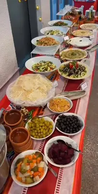 a long table filled with bowls and plates of food at Wadi Rum Sand Camp in Al Jafr