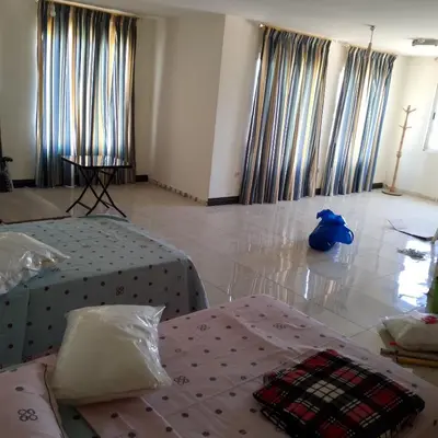 a bedroom with two beds and a blue bag on the floor at New Room in Aqaba