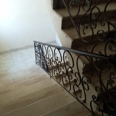 a staircase with a wrought iron railing and wooden floors at New Room in Aqaba