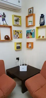 a room with a table and two chairs and pictures on the wall at swahmaya apartments for rent in Sowayma