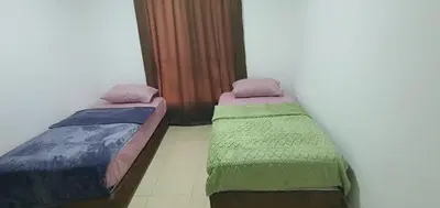 two beds sitting next to each other in a room at swahmaya apartments for rent in Sowayma