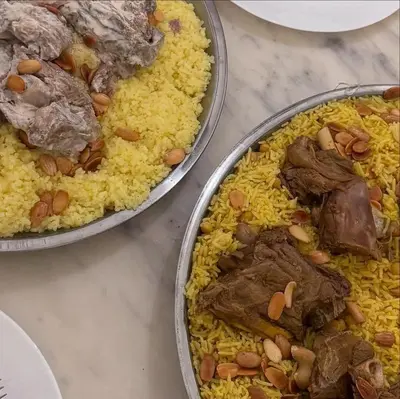 two pans of meat and rice on a table at فلورس لوج