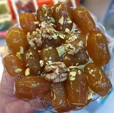 a hand holding a pile of food with nuts on it at الضليل هاوس in Abū Ghārah