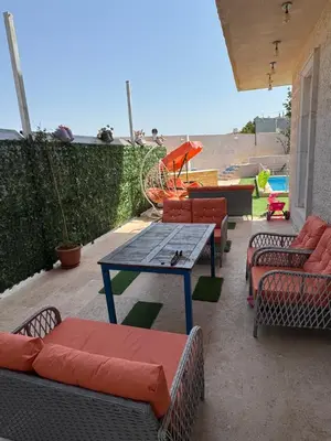 a patio with a table and chairs and a playground at مزرعة وشالية هوى الوادي
