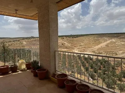 a balcony with potted plants and a view of a field at مزرعة وشالية هوى الوادي