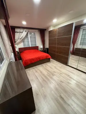 a bedroom with a red bed and wooden floors at مزرعة وشالية هوى الوادي