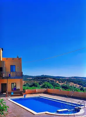 a swimming pool in front of a house at Mountain Oak Chalet شالية ملول الجبل in Al Jafr