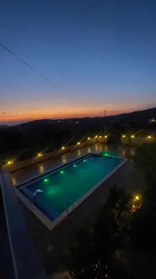 a view of a swimming pool at night at Mountain Oak Chalet شالية ملول الجبل in Al Jafr