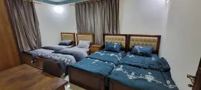 two beds in a bedroom with blue comforters at النخبة للشقق الفندقية AlNukhba suites in Irbid
