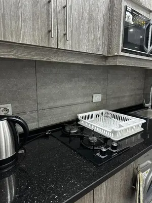 a dish rack sitting on top of a stove in a kitchen at alrabyeh studio 21 استوديو الرابية in Amman
