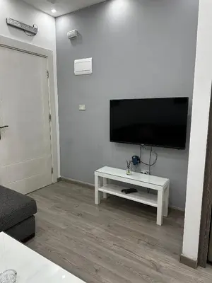 a living room with a tv and a white table at alrabyeh studio 21 استوديو الرابية in Amman