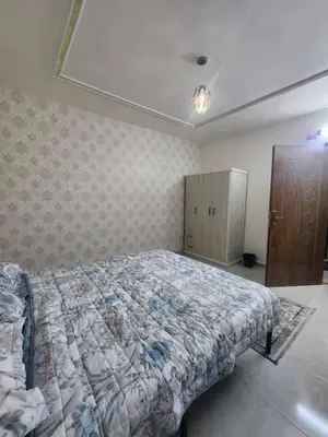 a bedroom with a bed and a cabinet in it at اللجين 6m in Irbid