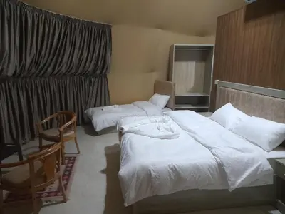 a hotel room with two beds and a chair at wadi rum gem in Disah