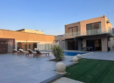 a patio with tables and chairs and a house at SunValley in Al Rama