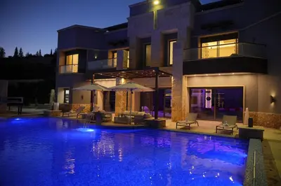a house with a swimming pool at night at Luxurious private villa in Mahis in Māḩiş