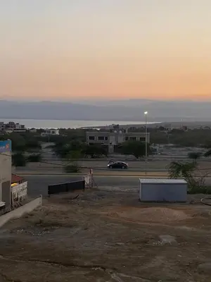 a parking lot with a car in front of a building at Nabila Chalet in Sowayma
