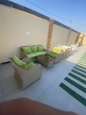 a patio with a couch and chairs and a table at Nabila Chalet in Sowayma