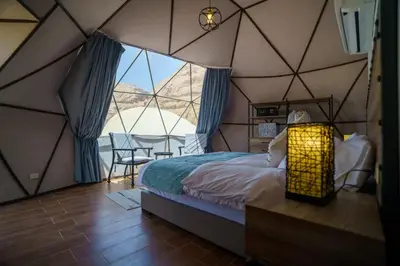 a bedroom with a tent with a bed and a table at Moon night camp in Disah