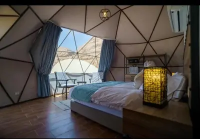 a room with a tent with a bed and a table at Moon night camp in Disah