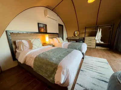 two beds in a room with an arched ceiling at Moon night camp in Disah