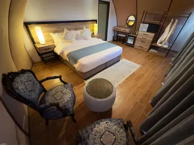 a bedroom with a large bed and two chairs at Moon night camp in Disah