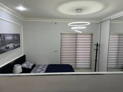 a bedroom with a bed and a chandelier at استوديو الجاردنز gardens studio 319 in Al Jafr