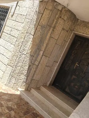 a stone wall with a door and stairs at ام الينابيع عجلون in Ajloun