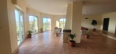 a lobby with potted plants and windows in a building at Romana in Ar Rummān