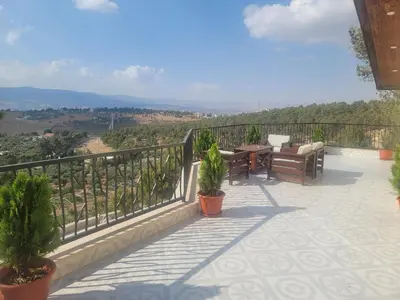 a patio with a table and chairs on a balcony at Romana in Ar Rummān