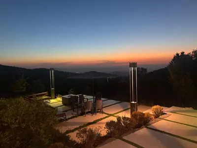 a patio with a table and chairs at sunset at AlFahed Farm in Ajloun