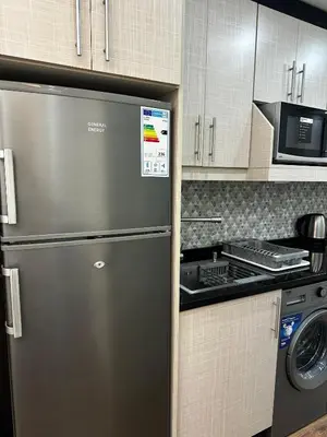 a kitchen with a stainless steel refrigerator and a stove at استوديو الرابية 19 studio alrabyeh in Al Jafr